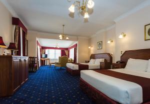 a hotel room with two beds and a chair at Palais Royale in Katoomba