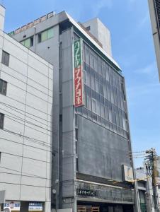 un bâtiment avec un panneau sur son côté dans l'établissement カプセル&サウナ日本 -男性専用 men only-, à Fukuyama