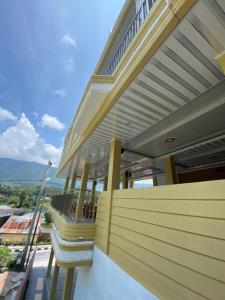 Cette maison jaune dispose d'un balcon avec une échelle. dans l'établissement Tama View, à Tuk Tuk