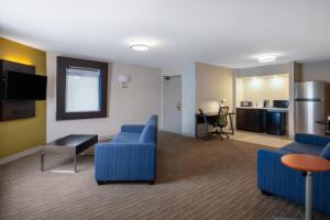 a living room with blue furniture and a kitchen at Holiday Inn Express Corydon, an IHG Hotel in Corydon