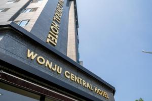 a sign on the front of the woolu centennial hotel at Wonju Central Hotel in Wonju