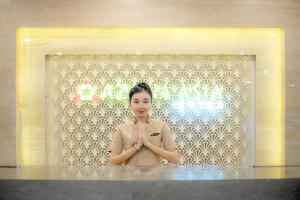 a woman standing in front of a window with her hands in aorativeorativeorative at Azana Asia Hotel Cilacap in Sidanegara +22 photos