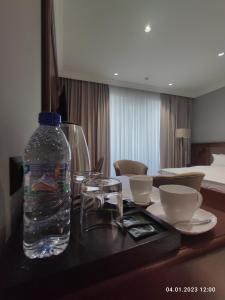 a bottle of water on a table in a hotel room at Mir Luxe Plaza in Tashkent