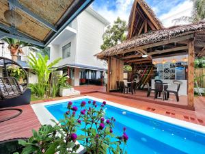 an outdoor patio with a swimming pool and a house at Siargao Seasky Resort in Catagnan