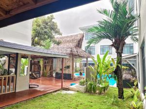 einen offenen Innenhof mit einer Palme und einem Gebäude in der Unterkunft Siargao Seasky Resort in Catagnan