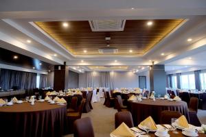 a banquet hall with tables and chairs in a room at Azana Asia Hotel Cilacap in Sidanegara