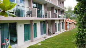 a row of buildings with green doors and grass at CaLu Hotel en La Laguna, Santa María del Oro in La Laguna