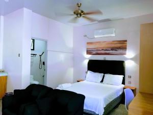 1 dormitorio con cama blanca y ventilador de techo en Marino Bungalows en Bantayan Island