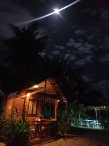 une maison la nuit avec une lumière au-dessus dans l'établissement Zhaya's Beach & Cottages, à El Nido