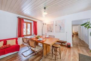 a dining room with a table and a red couch at Casa Traversi - Happy Rentals in Cevio