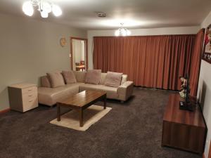 a living room with a couch and a coffee table at Airport accommodation in Christchurch