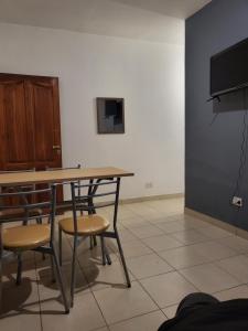 mesa y sillas en una habitación con TV en Hostal Nazarena Herrera en Salta