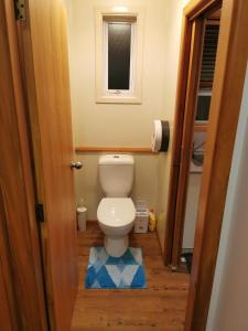 a small bathroom with a toilet and a window at Airport accommodation in Christchurch