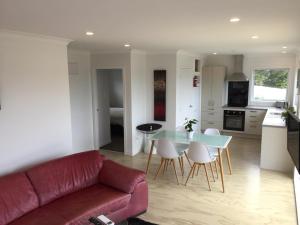 a living room with a couch and a table and chairs at Horizon View in Waihi Beach +6 photos