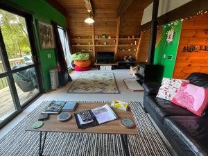 a living room with a couch and a table at Pointy Bird, Tranquility, rejuvenating,pets welcome in Hamurana