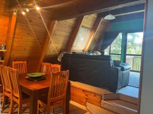 a dining room with a table and a couch at Pointy Bird, Tranquility, rejuvenating,pets welcome in Hamurana