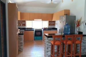 a kitchen with wooden cabinets and a counter with bar stools at La casa de Alex in Piura