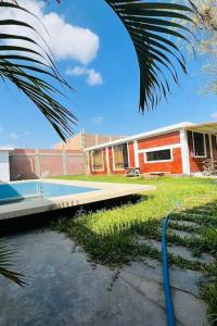 a building with a swimming pool in the yard at La casa de Alex in Piura