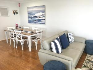 a living room with a couch and a table at Bermagui Beach Apartment in Bermagui