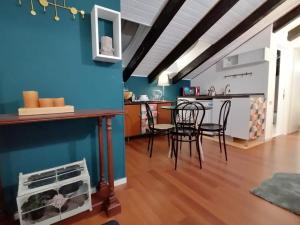 kuchnia i jadalnia z niebieskimi ścianami i krzesłami w obiekcie Mercanti Attic Version w Mediolanie