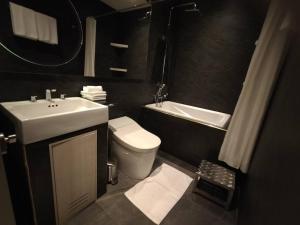 La salle de bains est pourvue d'un lavabo, de toilettes et d'un miroir. dans l'établissement Karnyapha Hotspring hotel, à Ban Lum Than