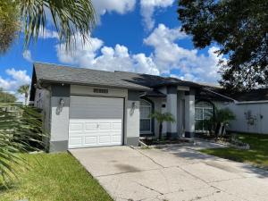 una casa blanca con garaje en Cozy 3 bedrooms home close to everything in Tampa! en Tampa