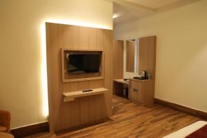 una habitación de hotel con TV y una habitación con en Hotel Crown Savoy, Near Railway Station & GURU NANAK DEV UNIVERSITY en Amritsar