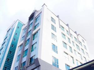 a tall white building with many windows at Swiss Hotel Apartment in Kuala Belait