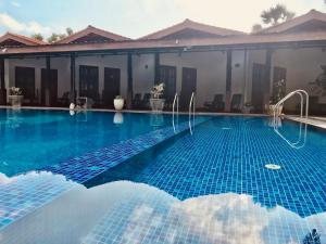 a swimming pool in front of a house at Paris Garden Resort in Trincomalee