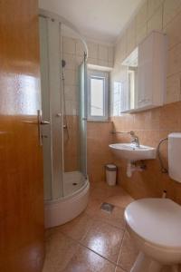 y baño con ducha, aseo y lavamanos. en Apartments Mir - close to beach, en Duće