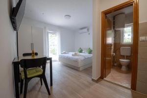 1 dormitorio con 1 cama y 1 mesa con silla en Apartments Mir - close to beach, en Duće