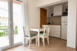 cocina con mesa y sillas y cocina con ventana en Apartments Mir - close to beach, en Duće