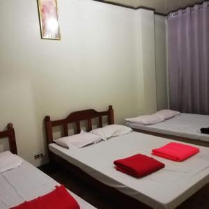 two beds in a room with red towels on them at Mj Transient Homes in Baguio