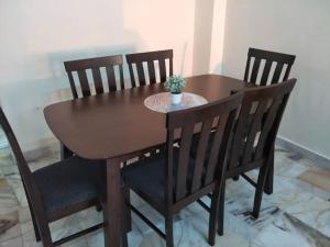 a wooden table with two chairs and a table with a plant on it at Sharaa seaview Apartment in Port Dickson