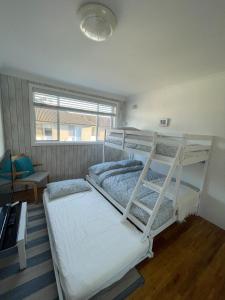 2 Etagenbetten in einem Zimmer mit Fenster in der Unterkunft Beachside Apartment Blackwoods Beach in Cronulla