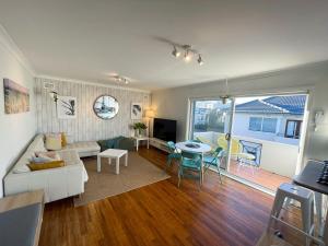 a living room with a couch and a table at Beachside Apartment Blackwoods Beach in Cronulla