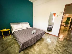 a bedroom with a bed with two white shoes on it at Lake View 53 Heritage 4BR by LOUIS in Taiping