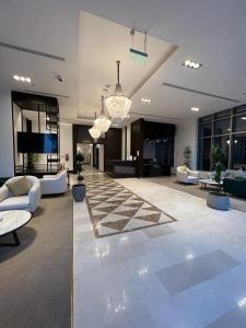 un gran vestíbulo con sofás y suelo a cuadros en Hotel ALdoliaa en Unayzah