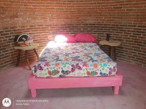 a bed in front of a brick wall at Glamping temax 
