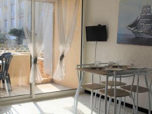 een tafel en stoelen in een kamer met een raam bij Appartement Port-la-Nouvelle, 2 pièces, 4 personnes - FR-1-229C-26 in Port-la-Nouvelle