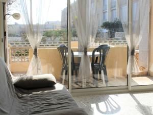 een kamer met een raam met een tafel en stoelen bij Appartement Port-la-Nouvelle, 2 pièces, 4 personnes - FR-1-229C-26 in Port-la-Nouvelle