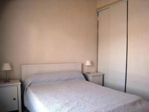 um quarto com uma cama branca e duas mesas de cabeceira em Maison L'Épine, 3 pièces, 5 personnes - FR-1-224B-515 em LʼÉpine