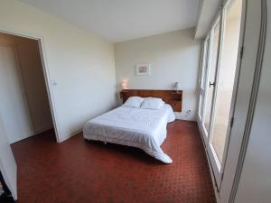 a bedroom with a white bed and a large window at Appartement Saint-Jean-de-Monts, 2 pièces, 5 personnes - FR-1-224C-262 in Saint-Jean-de-Monts