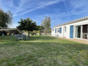 a house with a yard with a picnic table at Maison avec Jardin Clos près de la Plage - 5 Couchages, 3 Étoiles, Ménage Inclus - FR-1-224B-474 in Barbâtre
