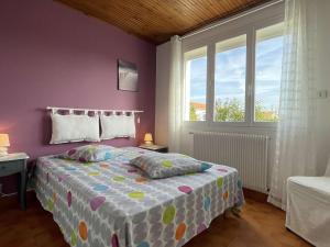 a bedroom with a bed and a purple wall at Maison avec Jardin Clos près de la Plage - 5 Couchages, 3 Étoiles, Ménage Inclus - FR-1-224B-474 in Barbâtre