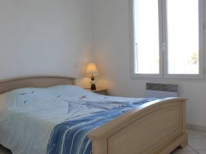 a bedroom with a bed with a blue blanket and a window at Maison Saint-Pierre-d'Oléron, 4 pièces, 5 personnes - FR-1-246A-12 in Saint-Pierre-dʼOléron