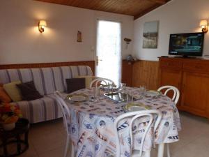 uma sala de jantar com uma mesa e um sofá em Maison Bretignolles-sur-Mer, 2 pièces, 4 personnes - FR-1-224A-586 em Bretignolles-sur-Mer