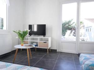 - un salon avec une télévision et une table dans l'établissement Maison Noirmoutier-en-l'Île, 3 pièces, 5 personnes - FR-1-224B-618, à Noirmoutier-en-l'lle