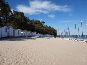 une plage avec une rangée de cabanes de plage et de pavillons dans l'établissement Maison Noirmoutier-en-l'Île, 3 pièces, 5 personnes - FR-1-224B-618, à Noirmoutier-en-l'lle