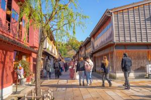 un grupo de personas caminando por una calle en 古都とき Kototoki en Kanazawa